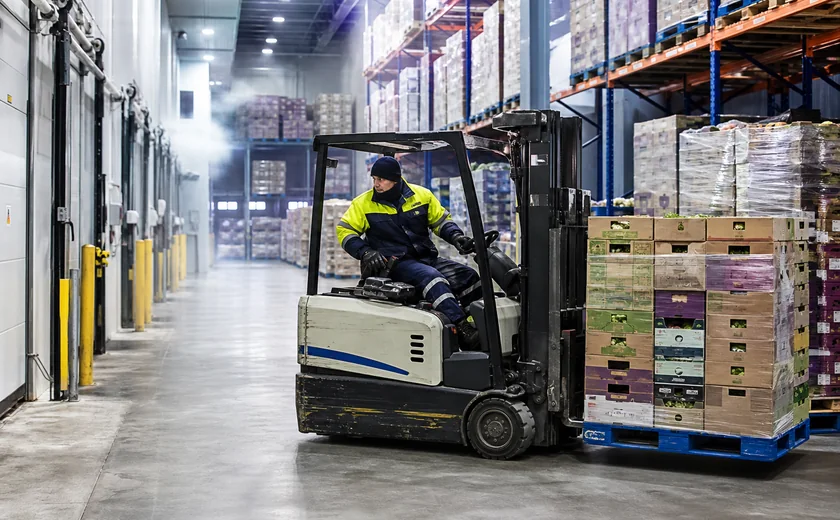 Forklift moving pallets inside a refrigerated distribution center