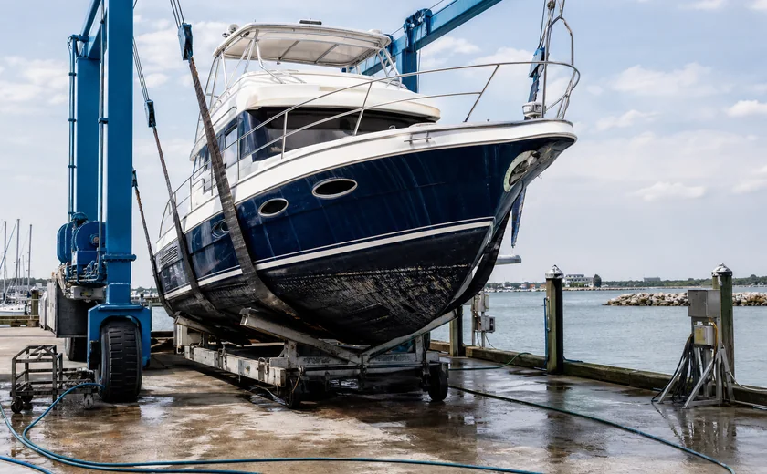 Motor yacht in a boatyard lift for hull maintenance